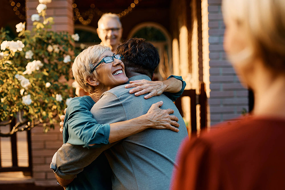 Happy senior woman embraces her son